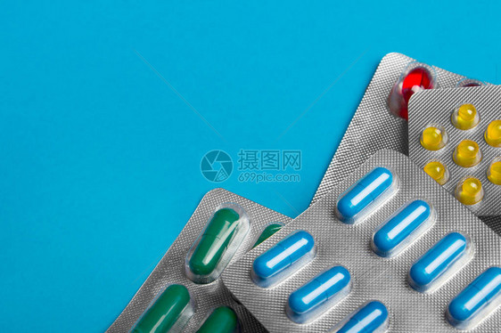 蓝色背景的彩色药丸药片和胶囊图片