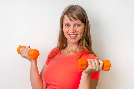 在健身房用哑铃锻炼的健身女人图片