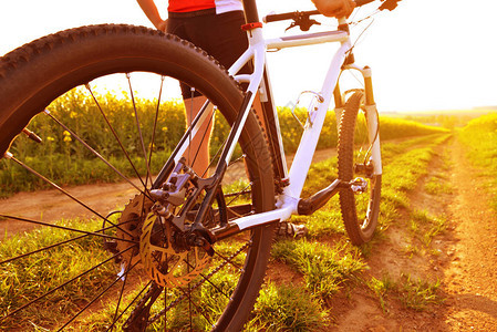日落时在泥土路上骑着山地自行车的赛车图片