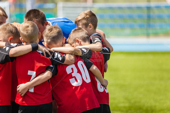 儿童体育足球队孩子们站在一起在足球场上足球教练激励人心的团队交谈青年足球足球教练激励运动员赛前图片