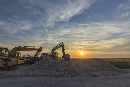 施工现场的挖掘机在令人惊叹的日落图片