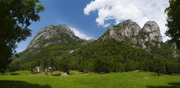 一个被花岗岩山脉和森林树木环绕的绿色山谷图片