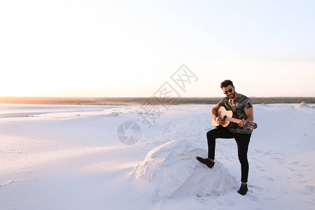 浪漫的留着胡须的阿拉伯年轻人用弦乐练习乐器图片