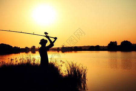 在黎明日落的景色下向河里扔一个支丝器的钓鱼图片