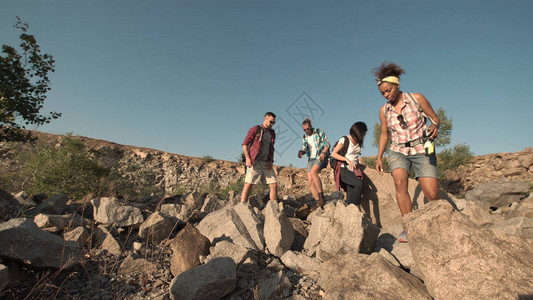 多族裔朋友群体在岩石上行走图片
