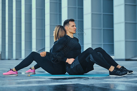 运动健美夫妇在现代建筑背景的有氧垫图片