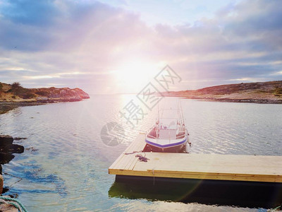 在日落平静的水面钓渔船一艘游艇用来在木制浮图片