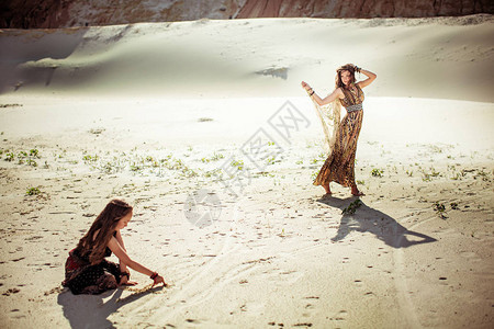 美丽的母亲和女儿在沙漠中带着孩子一图片