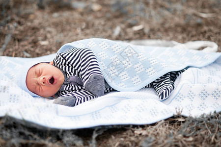 年幼的新生婴儿躺在草地上图片