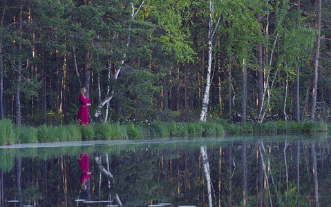 穿红裙子的年轻姑娘在湖图片