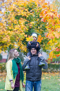 父亲母亲和儿子在秋天花园散步图片
