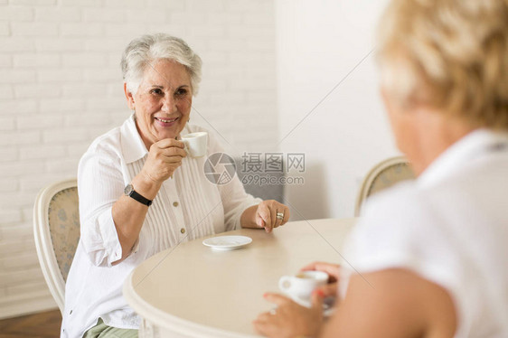 两个年长的女人在家里喝咖啡聊天图片