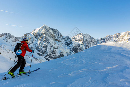 登山者偏远地区滑雪沿着雪脊行走图片