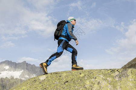 一位型登山者在瑞士阿尔卑斯山攀登山顶图片