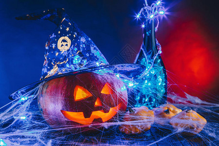 万圣节南瓜帽子在蜘蛛网上用糖果和昏暗的灯光和的上捣蛋的概念背景图片