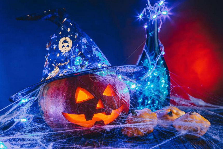 万圣节南瓜帽子在蜘蛛网上用糖果和昏暗的灯光和的上捣蛋的概念图片