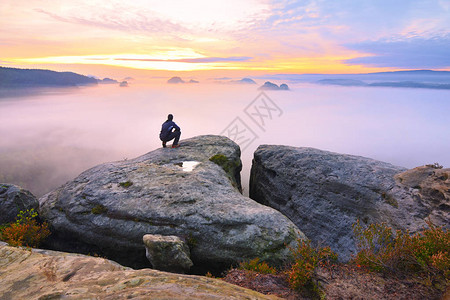 岩石峰顶上锋利的后方男子剪影满足徒步旅行者欣赏岩石峭壁的高个子观看下来风景生动而强图片