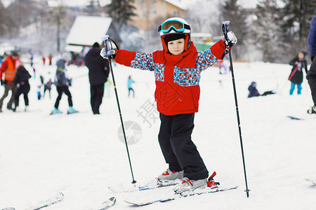 带着滑雪板和滑雪装备的可爱小男孩滑雪胜地的小滑雪者图片