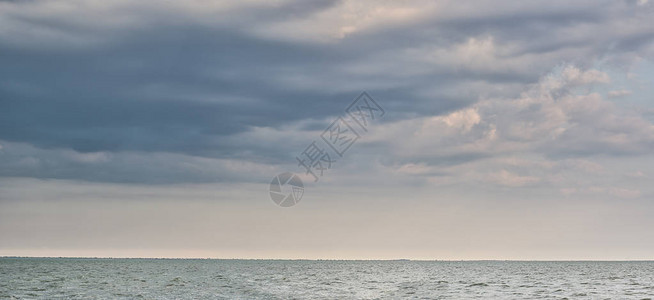 蓝色平静的海平面和有乌云的天空海景绿岛以及图片