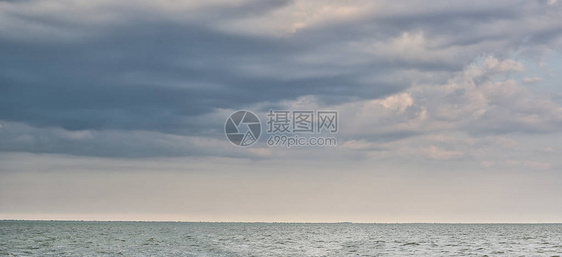 蓝色平静的海平面和有乌云的天空海景绿岛以及图片