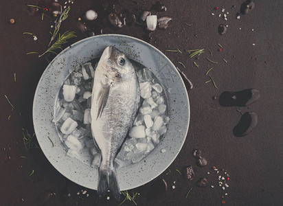 黑底灰色圆盘上的冰中新鲜多拉鱼海产食品餐厅有机烹饪材料顶视图片