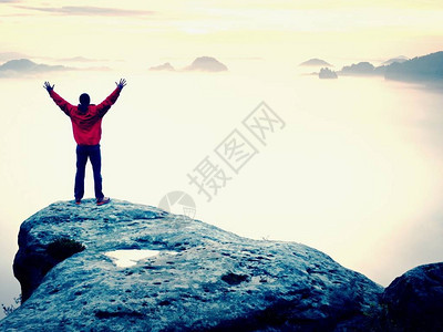 山顶快乐的人手势举起双臂有趣的徒步旅行者在公园岩石边缘的空中举起双手生动图片