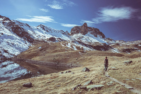 徒步旅行者在秋季观看高海拔景观和雄伟的白雪皑的山峰的壮丽景色在意大利法国阿尔卑斯山的广角拍摄色调图片