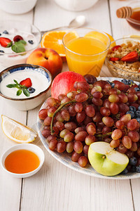 木桌上放着葡萄浆果和苹果的碗图片