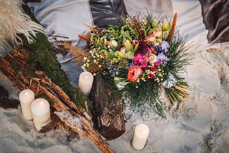 穿着布花风格的婚礼花束躺在沙子上图片