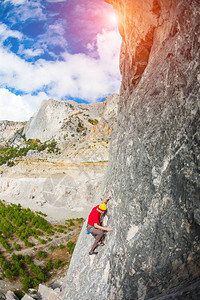 岩石上的攀岩者一个人在美丽的山景和云彩的背景下爬上岩石积极的生活方式自然运动克服困图片