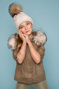 蓝色背景上穿着冬装帽子和带毛皮的冬装图片