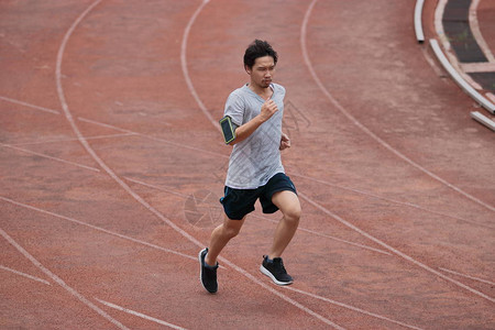 Athlete亚洲男子在体育场赛道上跑步健康活跃的图片