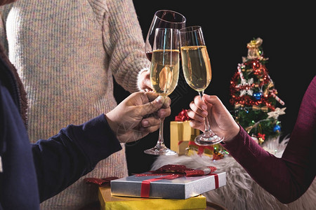 三个业务团队拿着香槟庆祝圣诞节和礼品盒在公司聚会图片