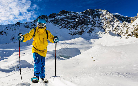 登山者偏远地区滑雪沿着雪山脊步行图片