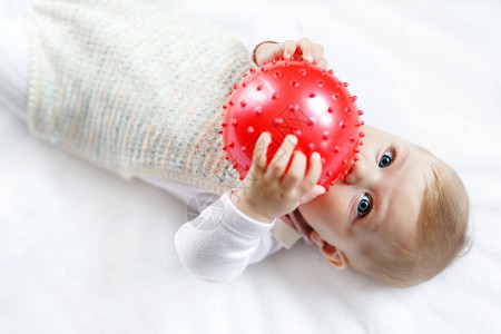 可爱的宝宝玩红胶球爬行抓图片