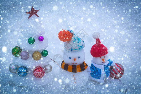 圣诞雪概念穿着衣服的笑脸雪人与星和球的圣诞树寒假庆祝概念圣诞节和蓝色图片
