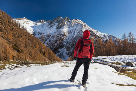 男人在冬天的山里背包旅行图片