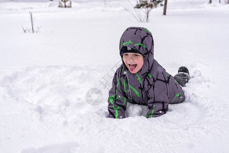 小男孩在雪中玩得开心下雪后活跃的冬季图片