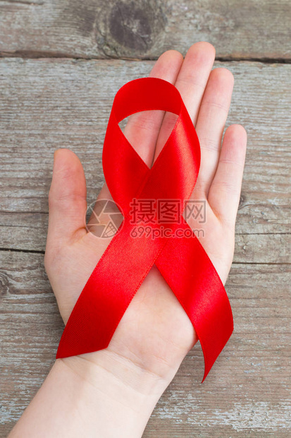妇女手上的艾滋病红丝带支持世界艾滋病日和艾滋艾滋病和老龄化图片