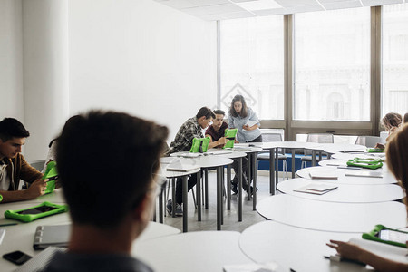 一群高中学生在现代圆桌教室用药片一起学习图片