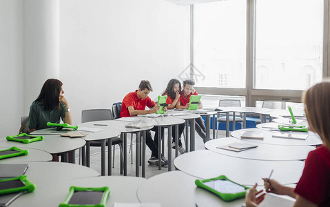 一群高中学生在现代圆桌教室用药片一起学习图片