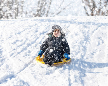 男孩在雪橇上滑雪冬图片