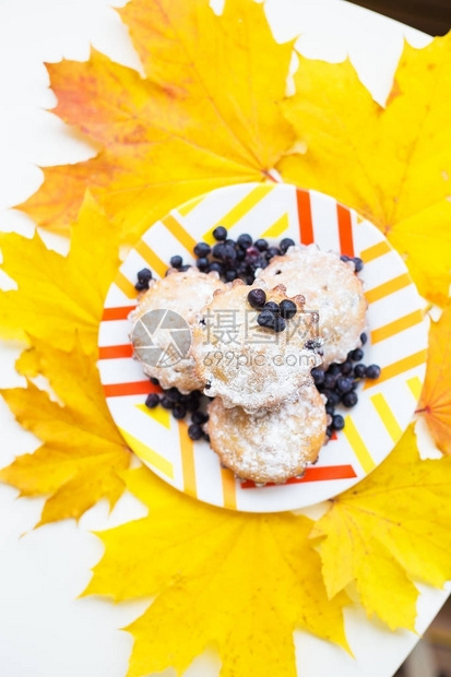蓝莓松饼盘色和黄秋叶的蓝图片