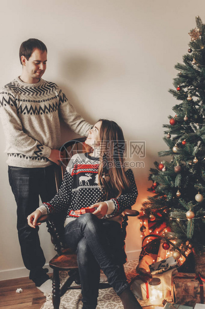 穿着毛衣的家庭情侣坐在圣诞树下图片