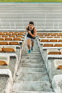 年轻健壮的男子在户外体育场的梯子上奔跑的形象年轻健康的人在楼梯运动轨道上运行运动和速度概念经过漫长的工作日后图片