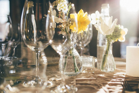 一瓶水夕阳下的婚宴用蜡烛和鲜花装饰的客人餐桌图片