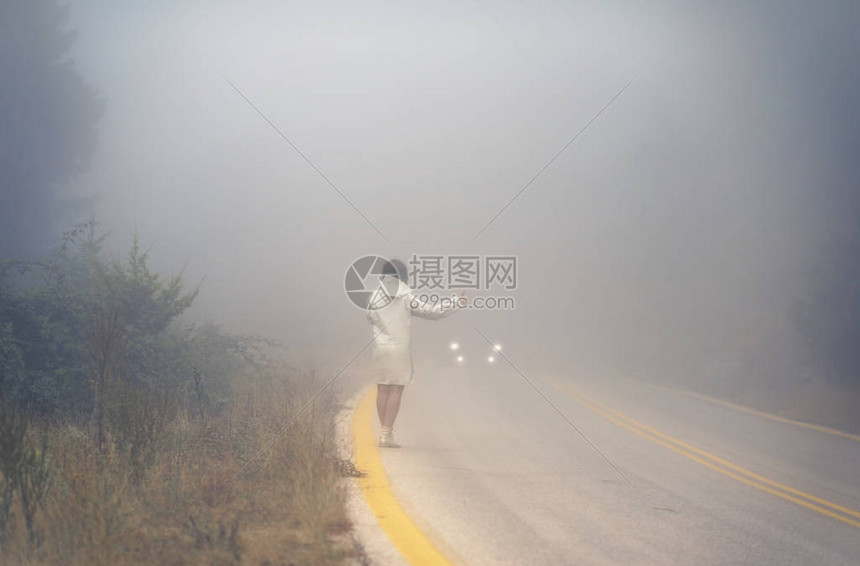 雾中路上穿着雨衣的年轻女穿雨衣的女在雨中图片