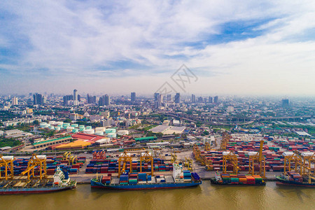 港口与城市物流和运输集装箱货船和货机与工作吊桥在船厂上午图片