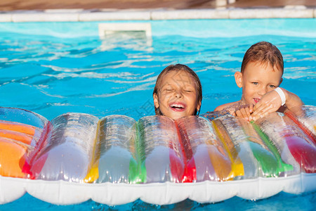 小孩在带气垫的游泳池里玩耍和玩耍孩子们在水中玩耍游泳概念男孩和女孩在暑假期间在度假图片