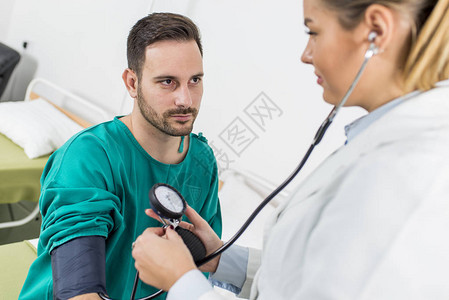 在诊所检查病人血压的女图片